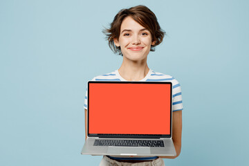 Young IT woman wears striped t-shirt casual clothes hold use work on laptop pc computer with blank...