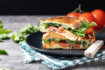 Healthy spinach, tomato and cheese sandwich on wooden table. Copy space