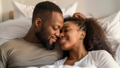 The man and woman in bed share smiles, exchanging joyful looks filled with happiness and comfort