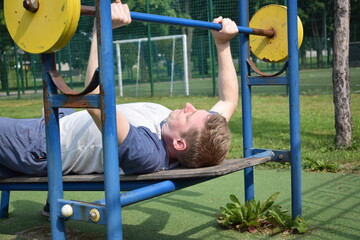 A dedicated young athlete puts in the hard work, vigorously training on gym equipment outdoors to...