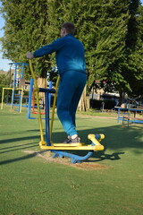 A dedicated young athlete puts in the hard work, vigorously training on gym equipment outdoors to...