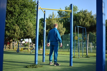 A dedicated young athlete puts in the hard work, vigorously training on gym equipment outdoors to...