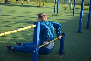 A dedicated young athlete puts in the hard work, vigorously training on gym equipment outdoors to...