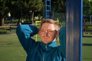 A dedicated young athlete puts in the hard work, vigorously training on gym equipment outdoors to...