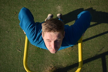 A dedicated young athlete puts in the hard work, vigorously training on gym equipment outdoors to...