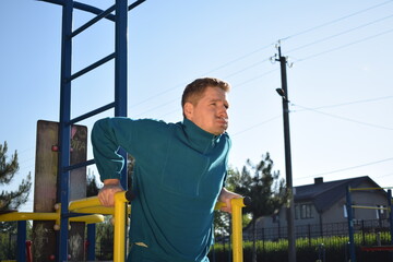 A dedicated young athlete puts in the hard work, vigorously training on gym equipment outdoors to...