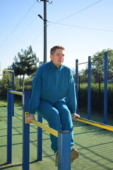 A dedicated young athlete puts in the hard work, vigorously training on gym equipment outdoors to...