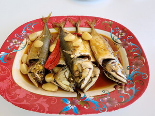 Stewed Mackerel Fish in Tamarind soup sprinkle with garlic and fresh chilies and serve on a red plate. Fish that is boiled with salt soup. Boil mackerel for 1-2 hours until the bones are tender.
