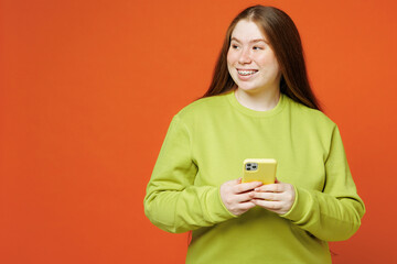 Young fat ginger chubby plus size woman wear green sweatshirt casual clothes hold use mobile cell...
