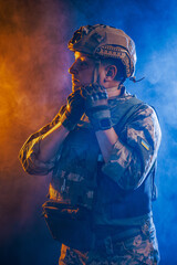 Portrait of a Tactical Soldier in Combat Gear against an Intense Orange and Blue Background