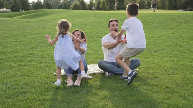 A diverse family enjoying time together in a green park during summer, sharing joy and connections. A carefree moment of togetherness