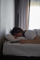 Fototapeta premium Young Woman Sleeping with Smartphone in Hand