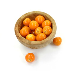 Uchuva (golden berry) delicious fruit isolated on white. Cape gooseberries in a wooden bowl. Fresh fruits of Physalis peruviana, also known as golden, inca and ground berry, uchuva, poha
