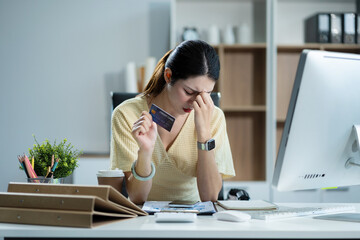 Business woman stressed with credit card debt to shopping online in internet website shop with computer laptop on work table in office.