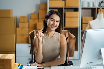 Portrait young attractive asian female owner startup business work happy with box at home prepare parcel delivery in sme supply chain, start up small business concept.