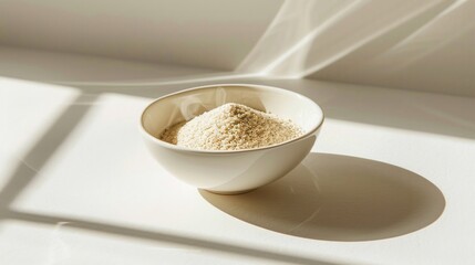 A photo of psyllium husk powder illuminated by a dramatic spotlight, casting long shadows in a white bowl,