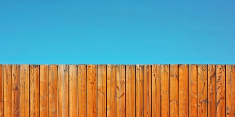Wooden fence against a clear blue sky. Concept of privacy, security, boundary, and home.