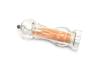 Glass hand mill with pink Himalayan salt isolated on white background with clipping path. Transparent condiment grinder. 