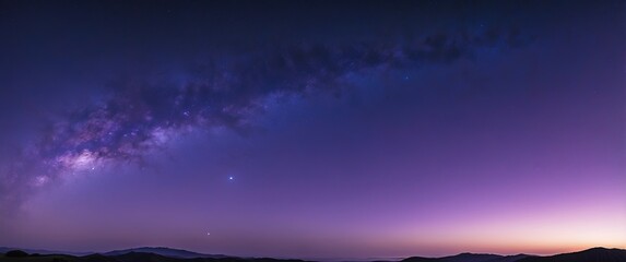 Fototapeta premium A breathtaking panoramic view of the Milky Way stretching across a twilight sky, blending hues of purple and blue, perfect for stargazing and tranquil retreats