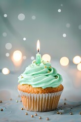 Delicious cupcake with mint green frosting and a lit candle, perfect for birthday celebration. Concept of bakery, pastry, dessert, sweet treat.