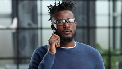 business people, communication and technology concep african american businessman calling on smartphone at office