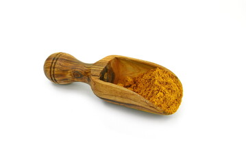 curry powder in a wooden scoop isolated on white background