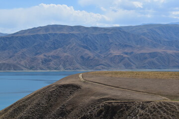 Long and winding dirt roads going through the countryside and mountains of Kyrgyzstan