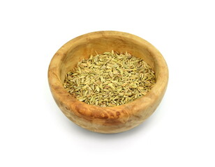 dried herb, fennel seeds in a wooden bowl, isolated on white, top view