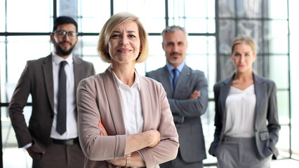 business woman with crossed arms against the background of a business team