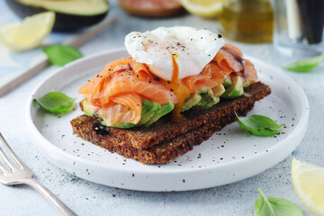 A rye bread sandwich with avocado and salmon	