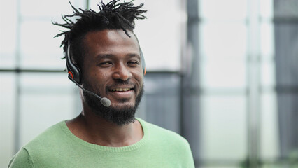 Smiling friendly handsome young male call centre operator.