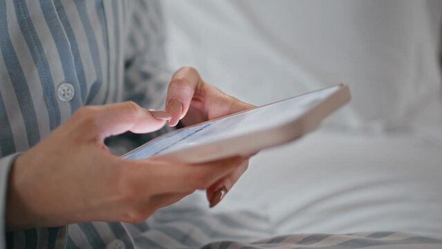 Girl hands texting mobile phone at bedroom closeup. Unknown woman messaging