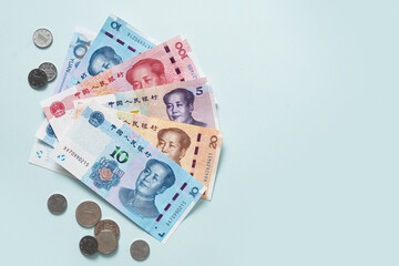 Many of different Chinese yuan banknotes. Chinese paper currency Yuan renminbi banknotes and coins on blue background. Copy space.