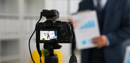 Male in suit and tie show stats graph pad making promo videoblog or photo session in office camcorder to tripod closeup. Vlogger selfie sale solution or finance advisor management information