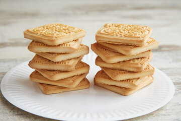 Cookies on a plate stacked on top of each other like two towers on a wooden table, cookies on a plate