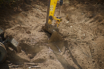 close-up, the excavator's bucket is shown in mid-dig