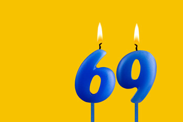 Blue candle number 69 - Birthday on yellow background