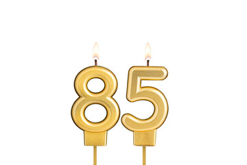 Golden number 85 birthday candle on white background