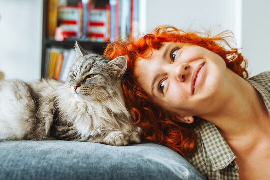 portrait red-haired attractive young woman with fluffy big cat