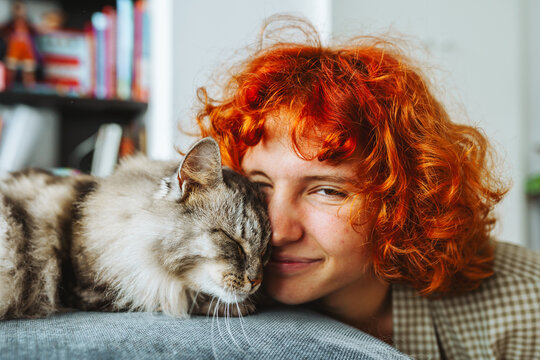 portrait red-haired attractive young woman with fluffy big cat