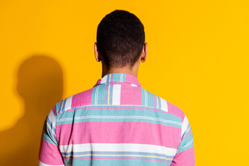 Photo portrait of pretty young male back view behind wear trendy striped outfit isolated on yellow color background
