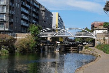 London - 06 04 2022: View of Salmon Lane pedestrian bridge and lock over Regent's Canal with Canada goose and her babies