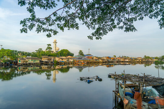 Local fishing village along the Bang Nara River with kolae boats colorful with a mosque in the background in the evening.