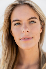 Obraz premium A close-up of a young and beautiful blonde woman with long hair flowing gracefully.