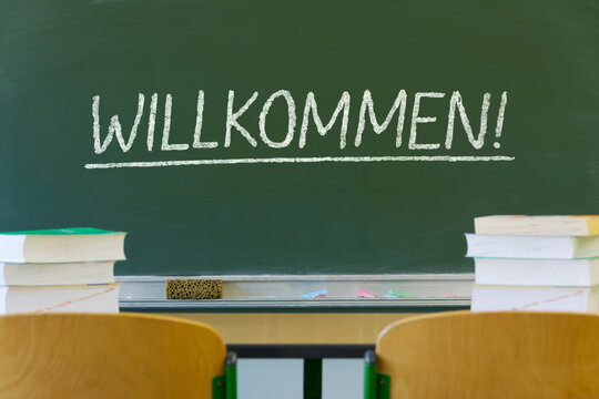 Schultafel im Klassenraum mit Kreideschrift "Willkommen"