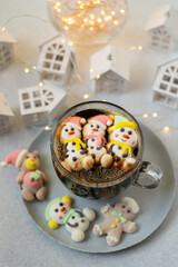 Cup of coffee with marshmallows. Marshmallow snowman in a Santa Claus hat. Winter drink. Christmas sweet food. Top view.