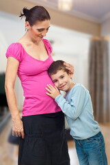 Fototapeta premium Child Listens to Pregnant Mother's Belly