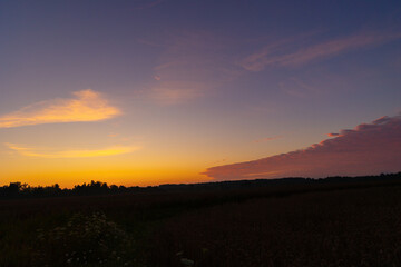 A beautiful minimalist landscape with colorful sunrise skies. Bright summer scenery of rural Latvia, Northern Europe.