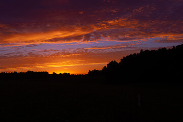 A beautiful minimalist landscape with colorful sunrise skies. Bright summer scenery of rural Latvia, Northern Europe.