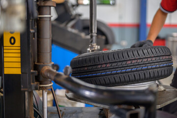 A car mechanic changing a tire. machine for rotating tires. A car mechanic in a workshop mounts a tire on a wheel.